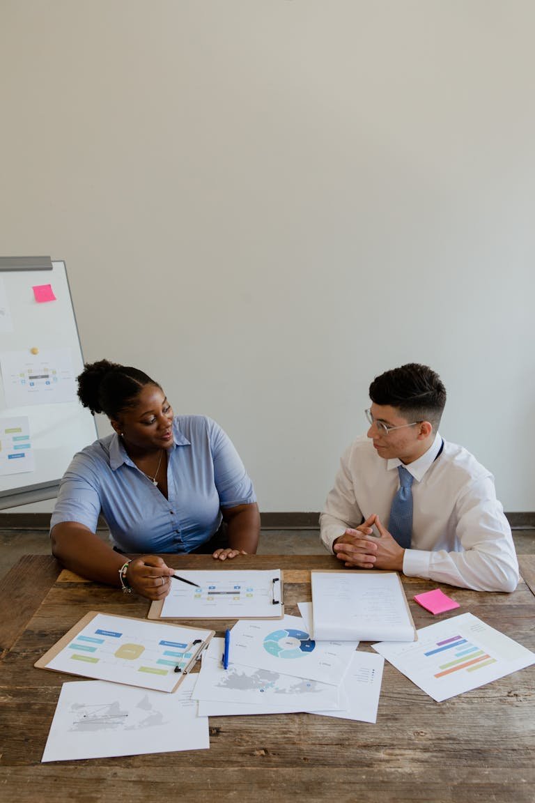 Coworkers Sitting at a Table with Documents and Talking